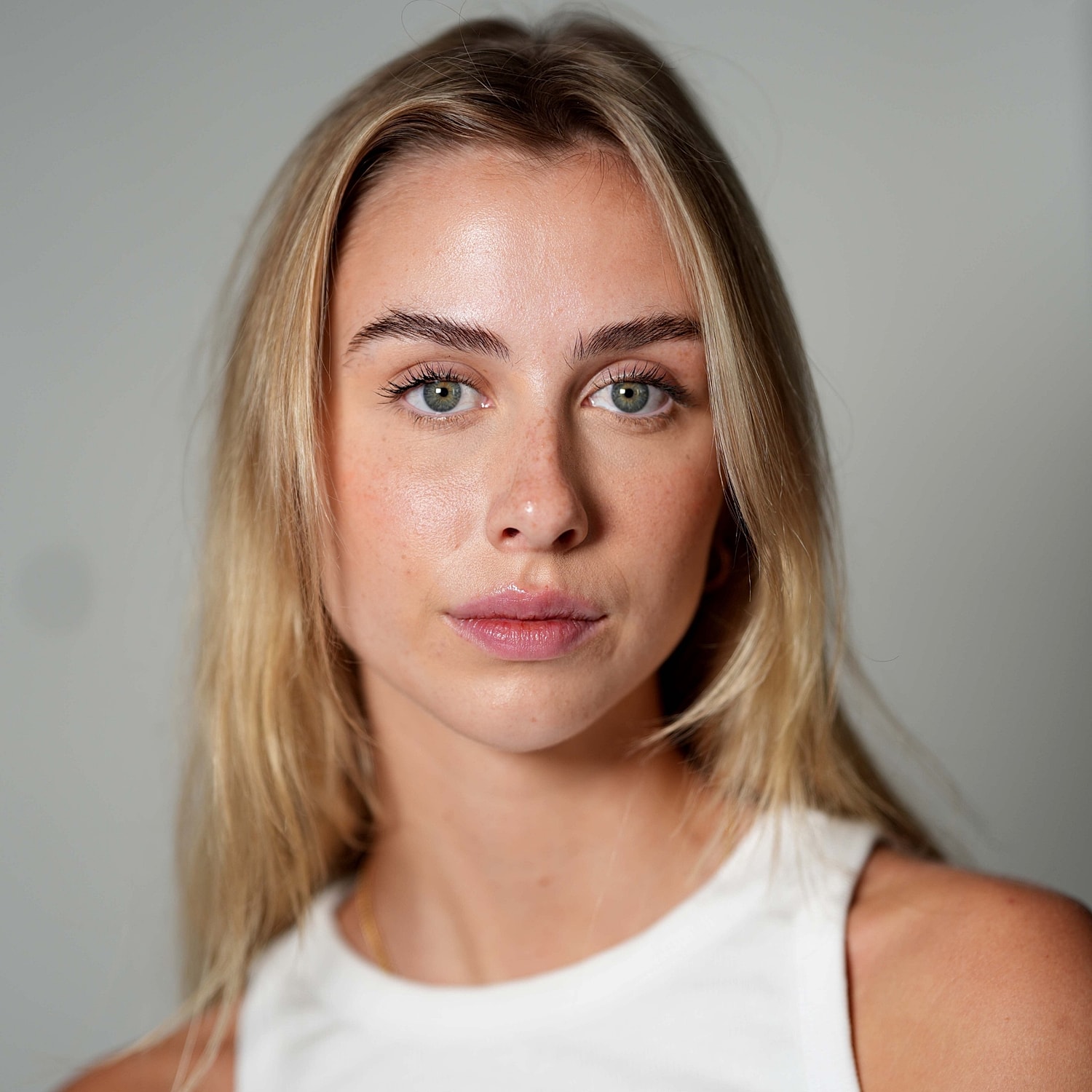 Portrait of a woman with blonde hair and green eyes.