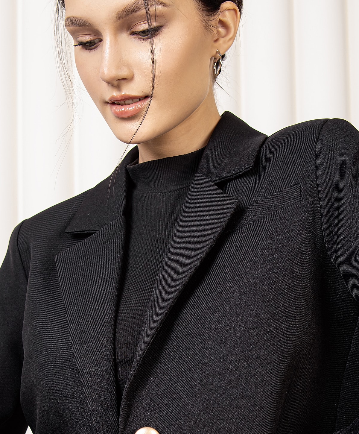 Woman in black blazer and sweater.