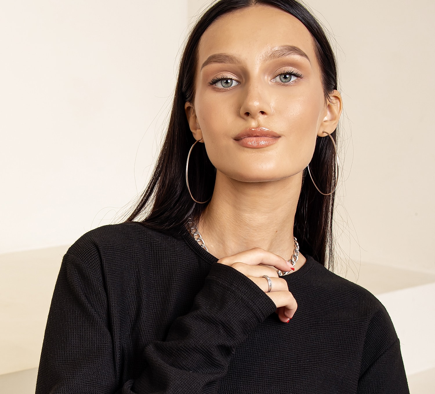 Woman in black top with hoop earrings.