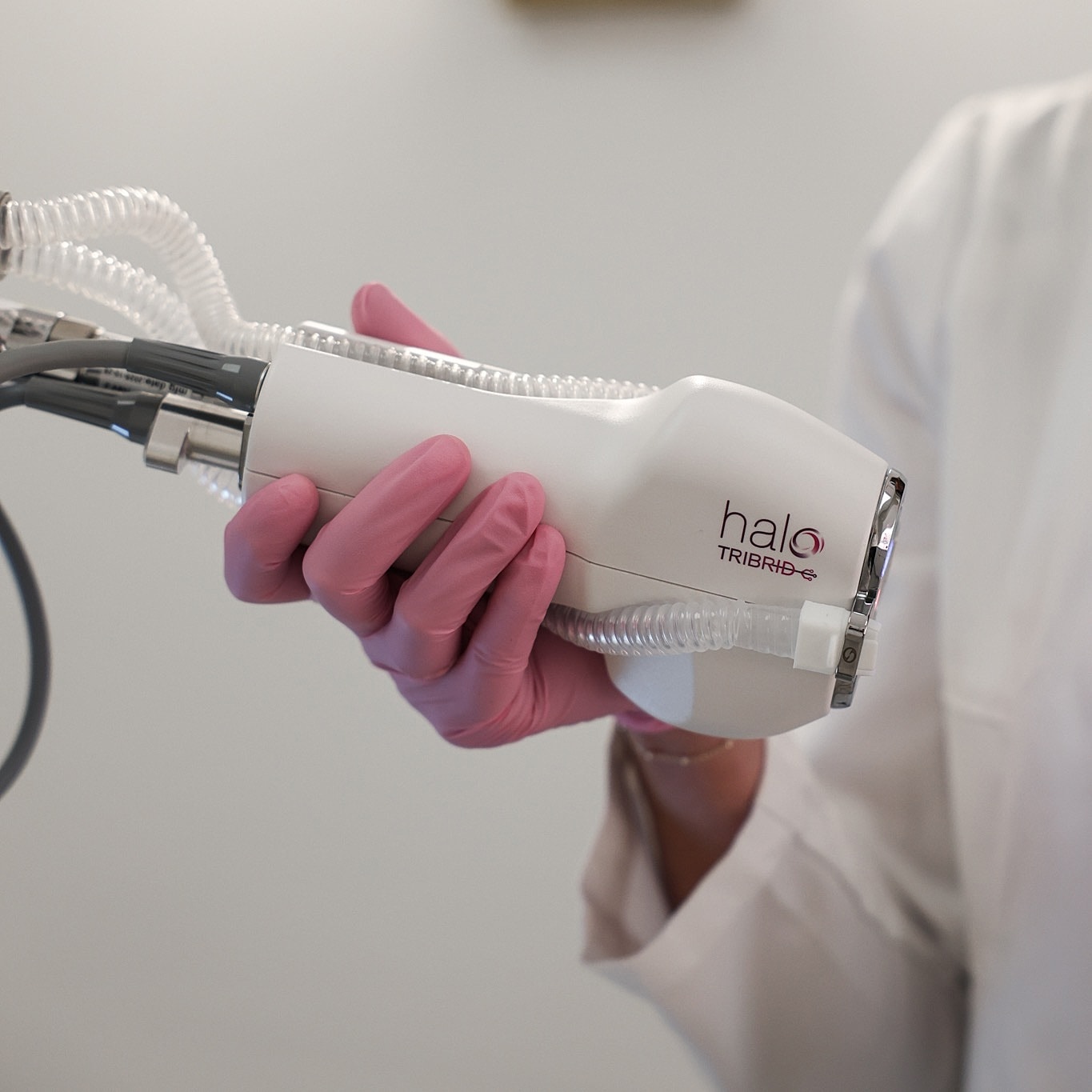 Hand holding a medical device for skin treatment.