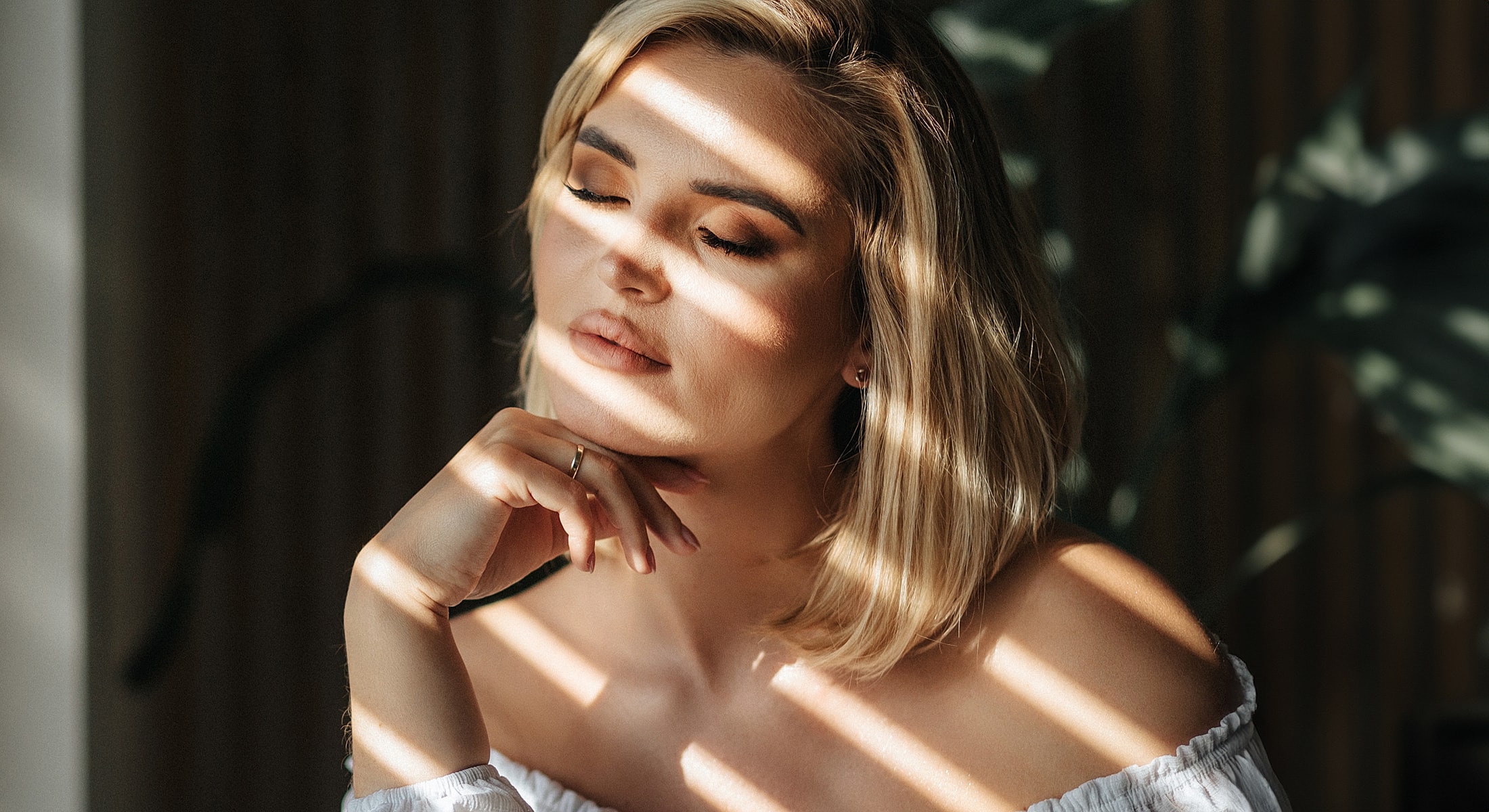 Woman with closed eyes in soft sunlight.